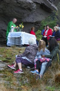 Parish priest Father Michael Moynihan saying mass at the Mass Rock at Inse an tSagairt.